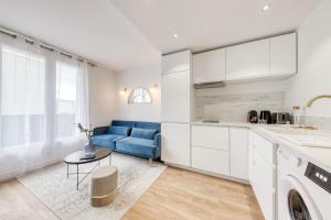 uma cozinha e sala de estar com um sofá azul em The Blue and Gold Cocoon Appart hotel em Viry-Châtillon