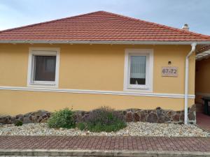 une maison jaune avec une allée en briques dans l'établissement Hillside Apartman, à Dunaszentmiklós