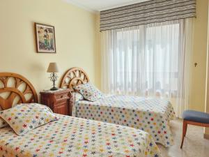 a bedroom with two beds and a window at Apartamento Florida EME in Sanxenxo