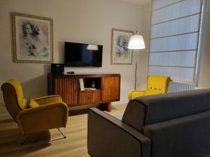 un salon avec un canapé, des fauteuils et une télévision dans l'établissement A casa di Marisa, à Rome