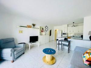 a living room with a couch a table and a kitchen at Comfy home with large terrace five minutes from ocean in Los Cristianos