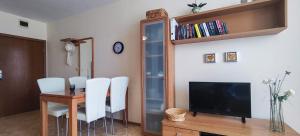 a dining room with a table with white chairs and a television at Elit 4 Apartments in Sunny Beach