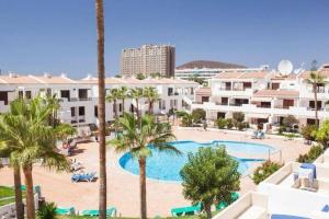 an aerial view of a resort swimming pool with palm trees at Comfy home with large terrace five minutes from ocean in Los Cristianos