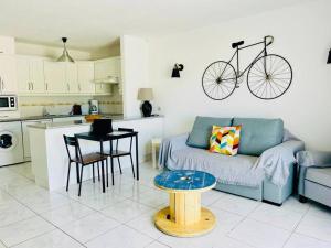 a living room with a couch and a bike hanging on the wall at Comfy home with large terrace five minutes from ocean in Los Cristianos