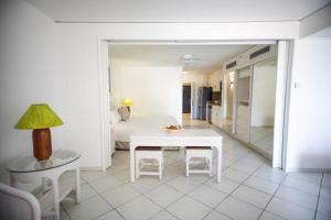 a white bedroom with a white table and a bed at Elegant Studio in Lowlands - 55 sqm - Pool in Lowlands