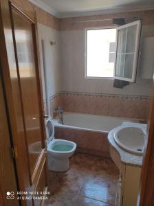 a bathroom with a tub and a toilet and a sink at Desconecta a pocos metros de playa y ocio in Los Alcázares
