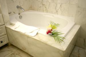 a white bath tub with a plant sitting on it at Elegant Studio in Lowlands - 55 sqm - Pool in Lowlands +6 photos