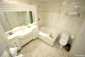 a bathroom with a tub and a toilet and a sink at Elegant Studio in Lowlands - 55 sqm - Pool in Lowlands