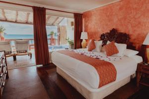 a bedroom with a bed with a view of the ocean at Hotel Aura del Mar in Zihuatanejo