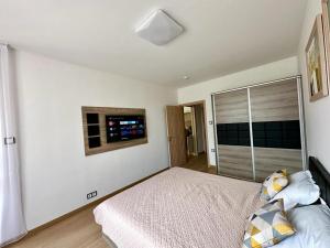 a white bedroom with a bed and a window at Royal Bay Аpartment Sylvia in Sveti Vlas