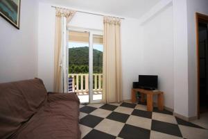 een woonkamer met een bank en een groot raam bij Cosy Apartment in Žrnovo - 30 sqm with Shared Pool in Korčula