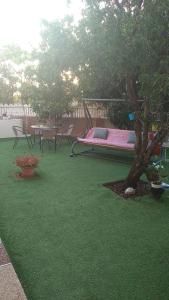 un parque infantil con una hamaca y un árbol en un patio en LTD Hadas Garden apartment en Tiberias