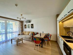 a kitchen and living room with a couch and a table at Royal Bay Аpartment Sylvia in Sveti Vlas