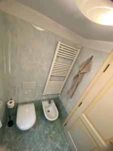 ein Badezimmer mit einem weißen WC und einem Waschbecken in der Unterkunft Casa Rossa - charmantes Ferienhaus in der Altstadt von Chioggia in Chioggia