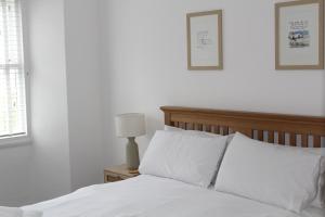 sypialnia z białym łóżkiem i białymi poduszkami w obiekcie Pike O'Blisco w mieście Bowness-on-Windermere
