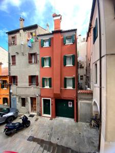ein rotes Gebäude mit einem davor geparkt in der Unterkunft Casa Rossa - charmantes Ferienhaus in der Altstadt von Chioggia in Chioggia