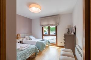 een slaapkamer met 2 bedden en een raam bij Bluebol, apartamento a 2 km de Llanes in Llanes