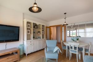 a dining room with a table and a tv at Bluebol, apartamento a 2 km de Llanes in Llanes