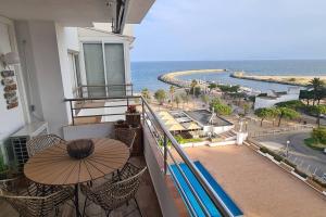 a balcony with a table and an umbrella and the ocean at Sunsetmare Vacational Apartment in Roses
