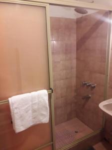 um chuveiro com uma porta de vidro ao lado de um lavatório em DCH Hostel Backpaquers em Concordia