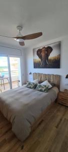a bedroom with a bed with a picture of an elephant on the wall at Sunsetmare Vacational Apartment in Roses
