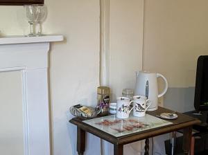uma pequena mesa com copos e um vaso sobre ela em Gilberts End Farm em Great Malvern
