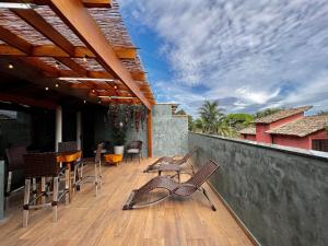a patio with chairs and a table on a deck at Casa a 3 min andando da Praia de Paúba com WIFI top in São Sebastião