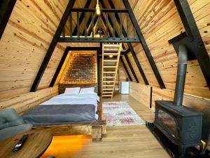 a bedroom with a bed and a wood stove at Tanura Bungalows in Çamlıhemşin