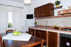 a kitchen with a table with a bowl of fruit on it at Capozafferano-Casa Carola in Santa Flavia