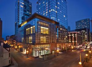 a large glass building in a city at night at Four Seasons Hotel Toronto at Yorkville in Toronto