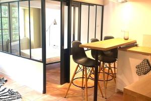 - une cuisine avec une table et des tabourets en bois dans l'établissement STUDIO COSY avec deux vélos COEUR DE VILLE, à Hyères 16 autres photos