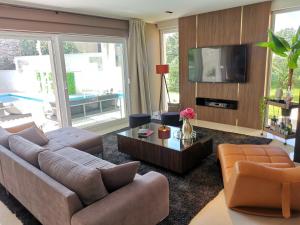 ein Wohnzimmer mit zwei Sofas und einem Fernseher in der Unterkunft Villa Santo in Babići