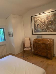 una camera con un letto, una sedia e un quadro di Terrazza sulle Isole Design&View a Stresa