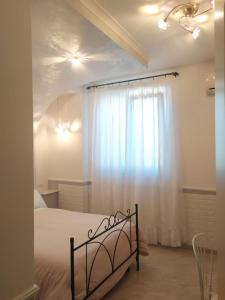 - une chambre avec un lit et un rideau blanc dans l'établissement L'orto del Vesuvio di Laura Guidone, à San Sebastiano al Vesuvio
