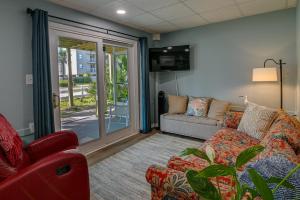 ein Wohnzimmer mit einem Sofa und einer Glasschiebetür in der Unterkunft Coastal Surfside Beach House Walk to the Ocean! in Myrtle Beach