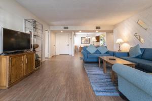 sala de estar con muebles azules y TV de pantalla plana en Casitas del Monte en Palm Springs