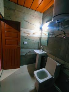a bathroom with a toilet and a sink at Chetna hotel & cottage in Manāli