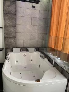 y baño con bañera blanca grande. en BRYSS HOTEL, en Santo Domingo de los Colorados