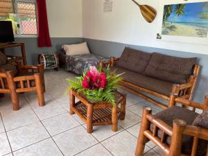 een woonkamer met een bank en een tafel met bloemen erop bij Chez Here - Ata in Faie