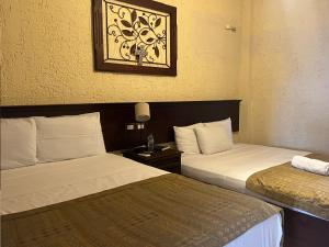 a hotel room with two beds and a picture on the wall at Hotel Quinta Maya in Flores