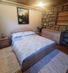 1 dormitorio con cama y pared de piedra en Apartment Sopar, en Škofja Loka