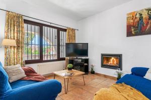 salon z niebieską kanapą i kominkiem w obiekcie Villa Capricho - PlusHolidays w mieście Calpe
