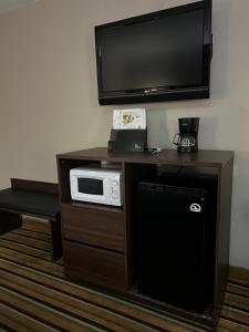 a room with a microwave and a television on a table at Super 8 by Wyndham Norcross/I-85 Atlanta in Norcross