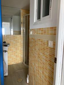 ein Bad mit gelben Wandfliesen und einer Dusche in der Unterkunft Apartamento 1ª linea de mar in Almería