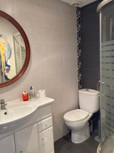 a bathroom with a toilet and a sink and a mirror at Apartamento 1ª linea de mar in Almería