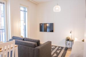 - un salon avec un canapé et une télévision murale dans l'établissement Snowflake suites V, à Rovaniemi