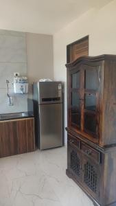 uma cozinha com um armário de madeira e um frigorífico em Manasvi em Mangalore