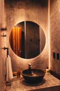 a bathroom with a sink with a large mirror at Naked Hotel Zipolite -Adults Only- in Zipolite +28 photos