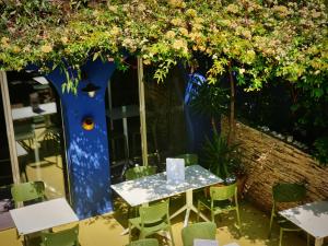 Sud Hôtel Restaurant في باستيا: طاولة وكراسي تحت شجرة بها زهور