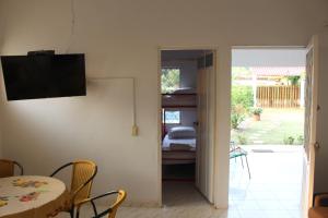 a living room with a table and a television on the wall at Cabaña Campestre Casablanca in San Juan de Arama